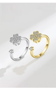 Detail view of adjustable gold and silver spinning four-leaf clover rings with zircon