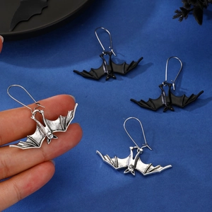 Detailed close-up of gothic bat pendant earrings in silver and black metal finish