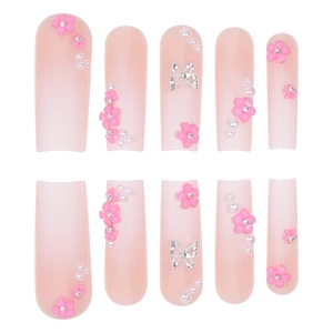 Pink gradient press-on nails with 3D floral accents, pearls, and silver butterfly charms