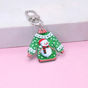 Detail of green glitter acrylic Christmas sweater keychain with snowman and metal clasp