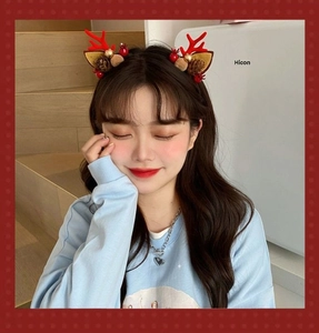 Close-up of Christmas reindeer antlers headband with pine cones and red berries detail