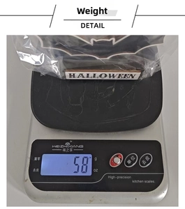 Mesure du poids d'une plaque en bois d'Halloween affichant 58g sur une balance de cuisine