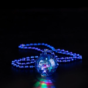 Close-up of a glowing blue spherical disco pendant on a matching beaded chain link