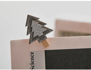 Close-up of a Christmas tree shaped wooden clip with black and silver glitter details