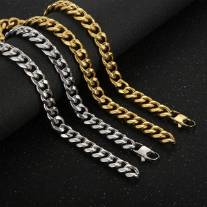 Set of gold and silver 11mm beveled Cuban link chains on a textured black background