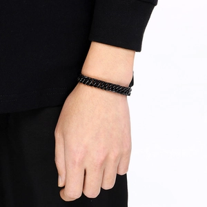 Close-up of a men's black titanium steel curb chain bracelet worn on a model's wrist