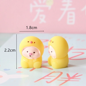 Close-up of a cute mini resin pig in a yellow bird hood showing 1.8cm x 2.2cm size