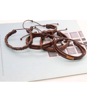 Macro view of handmade brown leather bracelets set with braided ropes and adjustable cords