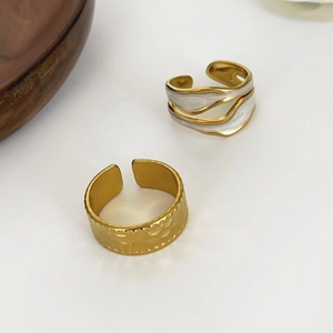 Minimalist 18K gold pleated ring with white enamel detail on white background
