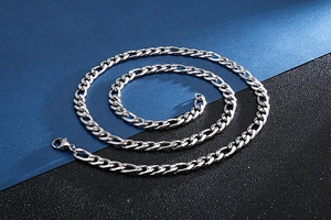 Gros plan d'un collier chaîne Figaro en argent poli avec maillons en acier inoxydable