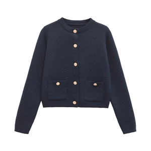 Close-up of knit cardigan with embossed gold buttons and decorative front pockets