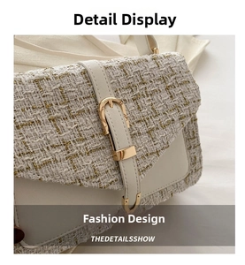 Detailed close-up of white and gold tweed texture with leather strap and metal buckle
