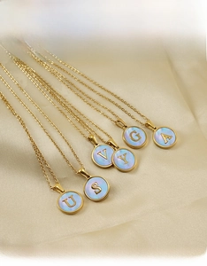 Détails macro des pendentifs alphabet plaqués or 18K avec incrustation de nacre