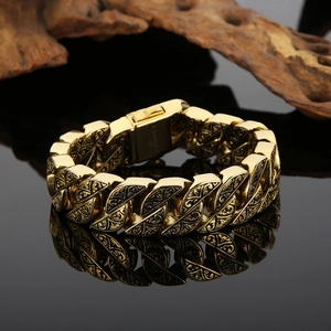 Close-up of a vintage gold chunky chain bracelet with intricate ethnic floral engravings