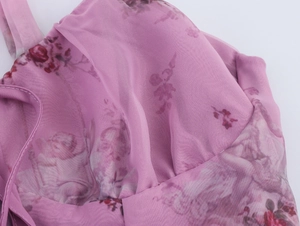 Detailed close-up of pink floral organza fabric with pleated bodice and stitched edges