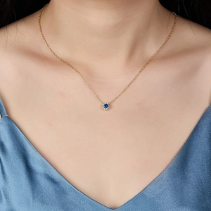 Elegant 925 sterling silver gold necklace featuring a round blue zircon pendant on model