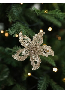 Gros plan d'un poinsettia doré pailleté avec résille ajourée sur un sapin de Noël