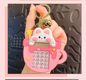 Close-up of pink rabbit on mini calculator keychain with gold bell and ring detail