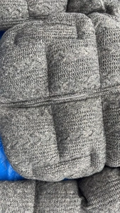 Detail showing grey quilted knit fabric texture and smooth metal zipper on the casual jacket