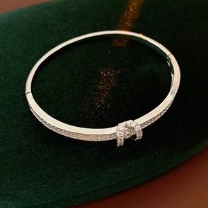 Macro detail of silver-tone oval buckle bracelet with pave-set cubic zirconia on velvet