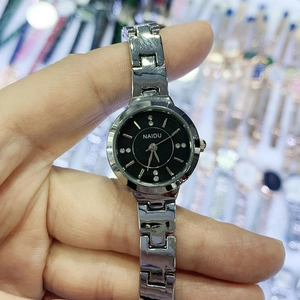 Close-up of elegant silver bracelet watch featuring a black dial with sparkling diamonds