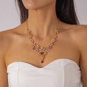 Detailed view of luxury gold floral pendant necklace with pink and white stones on model