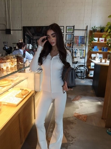Texture dettagliata del tessuto a coste bianco su giacca slim con zip e pantaloni svasati