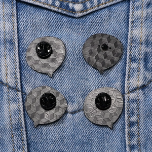 Set of four silver metal conversation bubble pins with black rubber backings on denim
