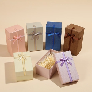 Detail of elegant rectangular gift box with ribbon bow and raffia paper filler inside