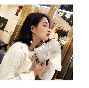 Silver woven evening clutch bag with gold tassel detail and matching long pearl earrings