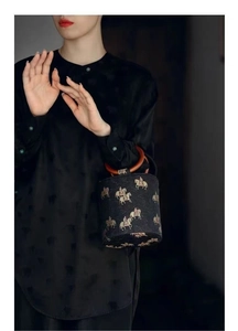 Close-up of vintage Song brocade bucket bag with wooden ring handles and horse embroidery