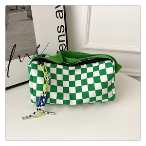 Detail showing green checkerboard Boston bag texture and blue SORAKA logo tag