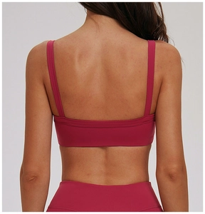 Dettaglio posteriore del reggiseno sportivo rosa scuro con spalline incrociate e design a U