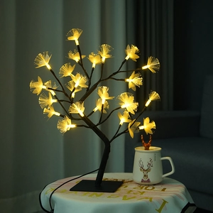 Close-up of birch fiber optic tree lamp with warm yellow blossoms on a cozy table
