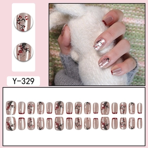 Detail of 24 champagne gold press-on nails with red plum flower patterns and oval shape