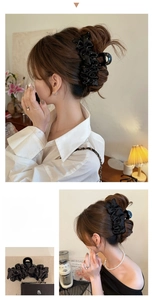 Détail de la grande pince à cheveux en satin plissé noir avec des pois blancs