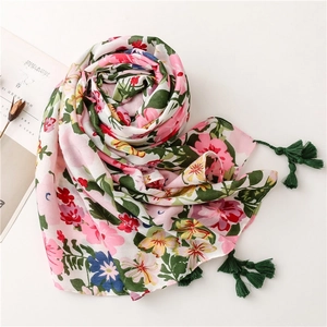 Detail of vibrant floral print cotton scarf with decorative dark green tassel trim