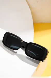 Detail of square black frame sunglasses with wide temples on a geometric surface