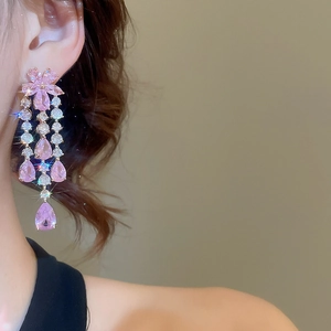 Side view of model wearing pink floral tassel earrings with luxury zircon drop charms