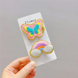 Plush embroidered rainbow and butterfly hair clips for girls on a white card display