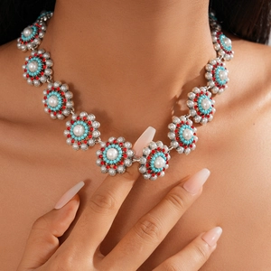 Close-up of bohemian floral necklace with pearls, turquoise beads and red rhinestones