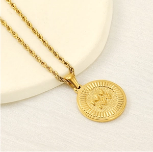Macro shot of 18K gold zodiac pendant with Aquarius wave symbol on a textured display