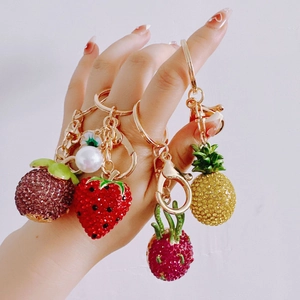 Detailed view of handmade fruit-shaped keychains with shiny rhinestones and gold chains