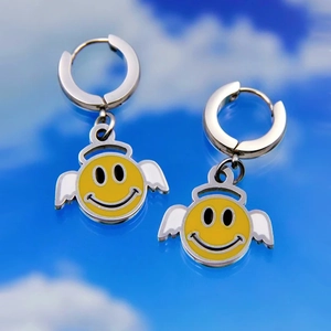 Detail view of silver stainless steel hoop earrings featuring yellow angel smiley face pendants