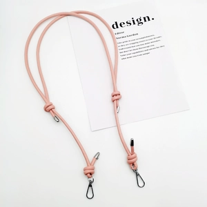 Detail of pink leather bag strap featuring a knot design and silver metal lobster clasps