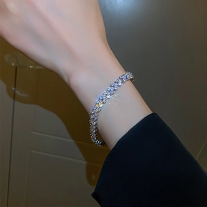 Close-up of sparkling zircon pavé bracelet in silver finish worn on female wrist
