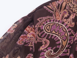 Close-up of bohemian paisley print on lightweight brown chiffon with ruffle edge detail