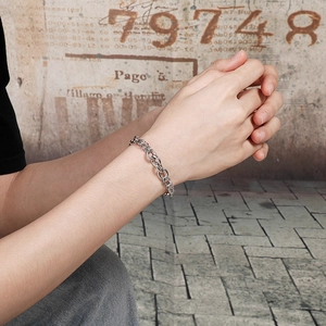 Detail of a silver punk-style dragon scale link bracelet worn on a wrist in close-up