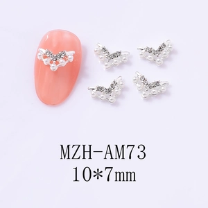 Macro detail of silver V-shaped hollow crown nail art charms with pearls and rhinestones