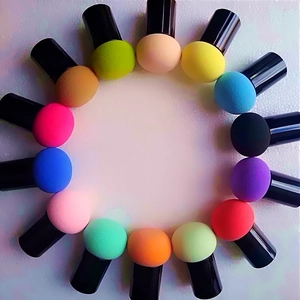 Colorful mushroom head makeup sponge set with black handles arranged in a circle on white back